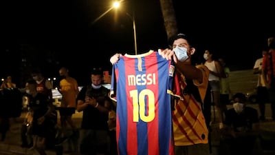 A Barcelona fan holds up a Lionel Messi shirt outside the Camp Nou. Reuters