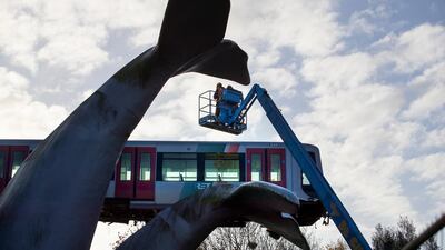 A salvaging crew prepares to attach chain to lift a metro train carriage off the whale's tail of a sculpture after it rammed through the end of an elevated section of rails in Spijkenisse, near Rotterdam, Netherlands. AP Photo