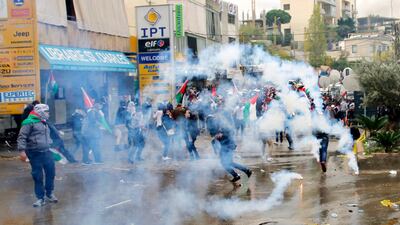 Protesters retreat from tear gas fired by riot police during a demonstration in front of the US embassy in Awkar, Lebanon, on December 10, 2017. Bilal Hussein / AP Photo