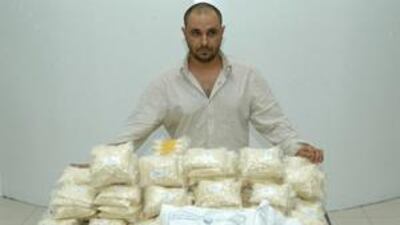 The suspect stands behind the seized half a million Captagon pills.