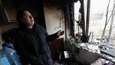 A woman looks at the damage in her flat after debris from a missile strike hit nearby, in Kyiv. EPA