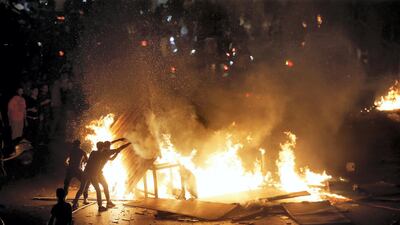 Demonstrators stand around a fire lit during protests in Beirut on October 18, 2019. Reuters