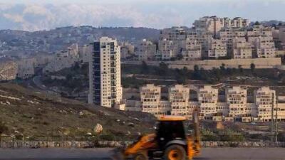 A bulldozer passes the large Jewish settlement of Har Homa near Arab villages and hills of the Judean Desert, where Israel plans to build thousands more units.