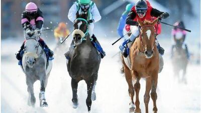 Winning jockey Fabian Weissmeier, right, rides Fanal el Samaw to a snowy victory in Switzerland on Sunday. Andy Mettler / Swiss Image