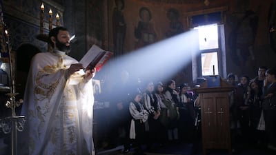 A Romanian Orthodox priest (L) sings to faithful during the Christmas Day mass held at the Orthodox church of Malaia village, Romania. EPA/ROBERT GHEMENT