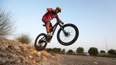 Andy Whitaker, who runs the Hot Cogs mountain bike club, gets a little airtime near the Dubai Autodrome in Dubai. Pawan Singh / The National
