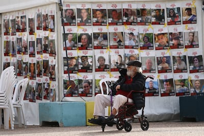 A man in a wheelchair sits by a wall of photos of hostages held in Gaza since October 7, 2023 at the so-called 'Hostages Square' in Tel Aviv, Israel. Reuters