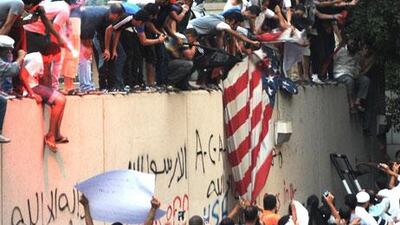 Egyptian protesters tear down the US flag at the US embassy in Cairo on September 11.