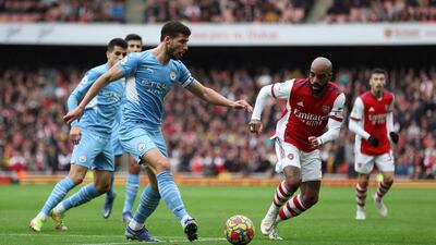 Manchester City's Ruben Dias battles with Arsenal's Alexandre Lacazette. Reuters