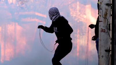 Palestinian protesters hurl stones at Israeli troops using slingshots during clashes with Israeli troops following a demonstration against the expropriation of Palestinian land by Israel, in the Israeli-occupied West Bank. AFP