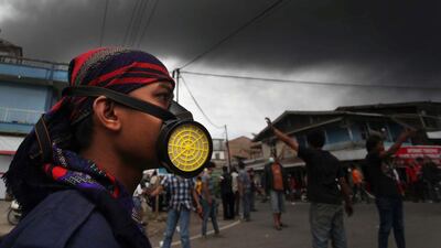 Residents of Karo district leave as an ash cloud rises during a fresh eruption of Mount Sinabung volcano. Ade Sinuhi / AFP Photo