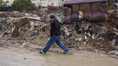 Basam Maswadeh, Kufr Aqab's village council head, is pictured trying to cross a road flooded with sewage and garbage on October 29, 2015. Heidi Levine for The National.