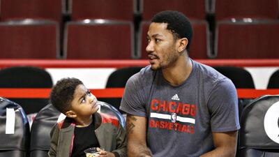 Derrick Rose Jr, left, looks up to his father, Chicago Bulls guard Derrick Rose, before an NBA basketball game between the Bulls and Atlanta Hawks. Charles Rex Arbogast / AP Photo