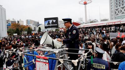 A security guard supervises fans of South Korean boy band BTS outside Tokyo Dome where the band's concert will be held in Tokyo, Japan. Kim Kyung-Hoon / Reuters
