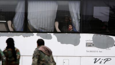 A boy looks through a bus window as rebels and civilians leave Harasta in eastern Ghouta, in Damascus, Syria on March 23, 2018. Omar Sanadiki / Reuters
