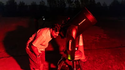 Visitors to the event enjoy the telescope observations in a dedicated area with telescopes set up to view a variety of astronomy. Antonie Robertson/The National