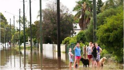 "Inland tsunami" expected to flood 6,500 homes and businesses as waters flow towards the Queensland state capital, Brisbane. Above, residents are seen near homes surrounded by flood water yesterday in Oakey, Australia.