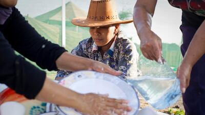 Leah Mariano, centre, a housekeeper for a local family, washes dishes with her colleagues Elina Talaboc, right, and Khadeeja Adis. "It's very exciting to get out of Dubai even if camping is hard work," Leah says.