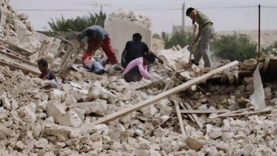 Iranians collect their belongings from the rubble of their home in the village of Darvisheh, southeast of Bushehr.