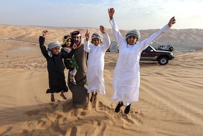 An Emirati family on top of the Tal Mor'eb dunes during Liwa Festival 2025. Victor Besa / The National