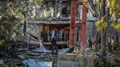 Afghan security personnel inspect the site of the explosion.