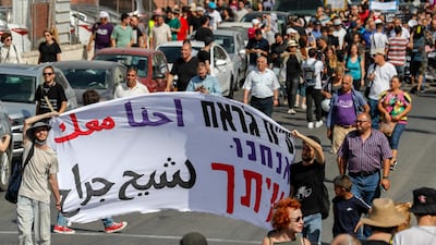 Demonstrators in East Jerusalem carry a banner that reads: " We are with you Sheikh Jarrah." AFP