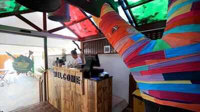 A frangipani tree around which the Art House Cafe in Abu Dhabi was built is decorated with material cut from discarded T-shirts. Ravindranath K / The National