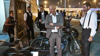Two dapper suited Gentlemen watch the arrival of fellow bikers outside Cafe Rider in Al Quoz for the start of the Distinguished Gentleman’s Ride 2014 in Dubai.