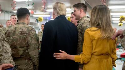 President Donald Trump and first lady Melania Trump pose for a photograph as they visit with members of the military at a dining hall at Al Asad Air Base, Iraq. AP Photo