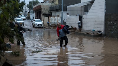 People wade through a flooded street after heavy rainfall in Sulaimaniyah province. Reuters