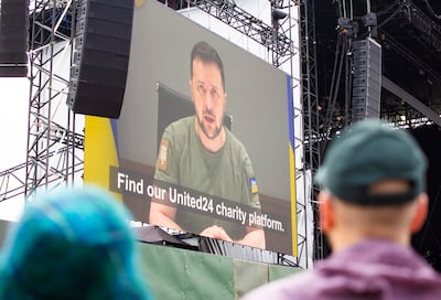 Glastonbury festivalgoers watch a recorded message from the President of Ukraine, Volodymyr Zelenskyy. EPA