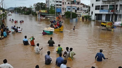 Residents up to their waists in floodwater in Vijayawada. AP