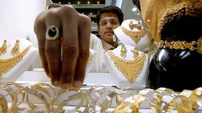 A salesman arranges a display of gold jewellery at a Pure Gold shop in Deira, Dubai. Pawan Singh / The National