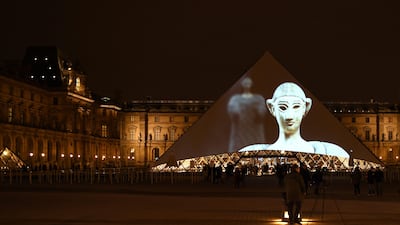 Images of the art displayed in the Louvre Abu Dhabi are projected onto the Louvre Pyramid in Paris Wednesday night to mark the opening of the museum on Saadiyat island. Eric Feferberg / AFP