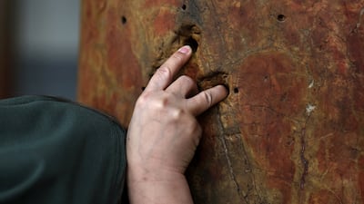 Christian pilgrim at Church of the Nativity in Bethlehem, West Bank, which has a column with five holes said to represent the five wounds of Jesus and forming the shape of a cross. EPA