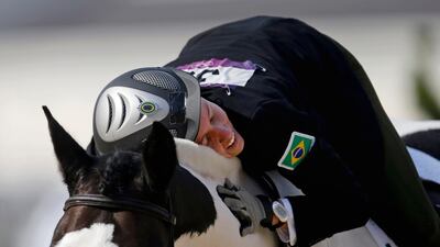 Yane Marques, of Brazil, pats her horse Over The Odds after completing the course in the equestrian show jumping stage of the women's modern pentathlon. David Goldman/AP Photo