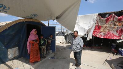 Displaced Iraqis stand outside a tent where they are taking shelter in a camp for internally displaced people near al-Khalidiyeh in Iraq's western Anbar province. While the election campaign is in full swing elsewhere in Iraq, the country's displaced camps barely register on the radars of those running for office, despite housing hundreds of thousands of people. Ahmad Al Rubaye / AFP