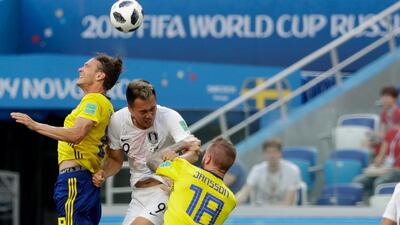 South Korea's Kim Shin-wook, centre, jumps for the ball against Sweden's Albin Ekdal, left, and Pontus Jansson. David Josek / AP Photo