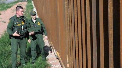 US agents examine the border between Arizona and Mexico in the town of Nogales.