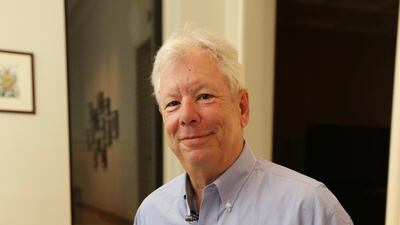 Richard Thaler poses for a photo with his books at his home in Chicago after winning the Nobel prize in economics. Anne Ryan / University of Chicago via AP