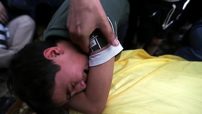 The son of Palestinian man Hani Abu Sha'ar, who was killed in an Israeli air strike, mourns over his father's body during his funeral in the southern Gaza Strip. REUTERS