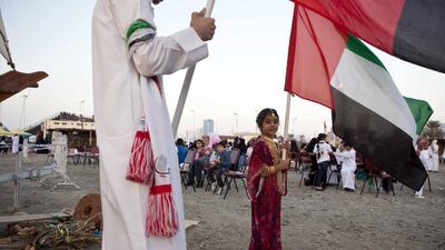 A young girl proudly hoists the UAE flag in Sharjah. Antonie Robertson/The National