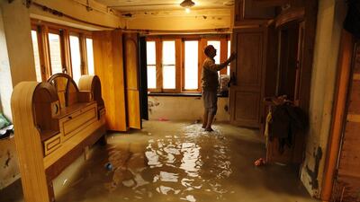 A Kashmiri man inspects wooden lockers inside his flooded house as he moves his valuables to safer places in Pampore. Mukhtar Khan / AP Photo