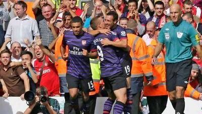 Arsenal's Santi Cazorla, centre left, celebrates with teammate Lukas Podolski after scoring against Liverpool during their English Premier League soccer match at Anfield Stadium, Liverpool, England, Sunday, Sept. 2, 2012. (AP Photo/Jon Super)