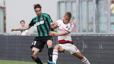 Sassuolo's Federico Peluso, left, and AC Milan's Keisuke Honda in action during their Italian Serie A match at Mapei stadium in Reggio Emilia, Italy, on May 17, 2015. Elisabetta Baracchi / EPA