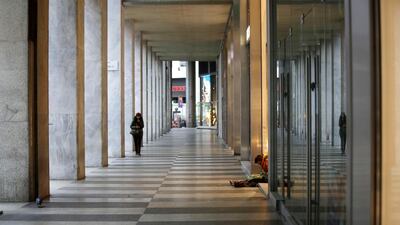 A man sits in downtown Milan. AP Photo