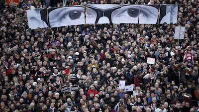 A card display representing the eyes of murdered Charlie Hebdo editor Stephane Charbonnier look out over a solidarity march in Paris at the weekend. Charles Platiau / Reuters