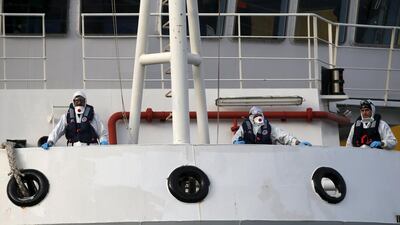 Italian coastguard personnel in protective clothing stand on the deck of their ship ‘Bruno Gregoretti’, carrying dead immigrants on board, as it arrives in Senglea, in Valletta’s Grand Harbour. Darrin Zammit Lupi / Reuters