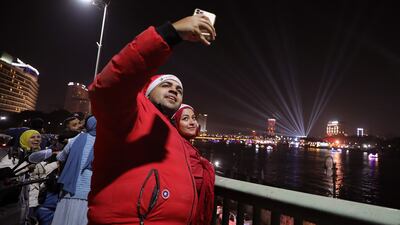 People take pictures as fireworks explode around the Cairo tower during the New Year celebrations, in Egypt. EPA