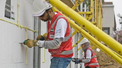 From left, Abed Al Blooshi and Iman Ustadi, hard at work rebuilding the home of Leslie Morris, which was destroyed by Hurricane Sandy in 2012.